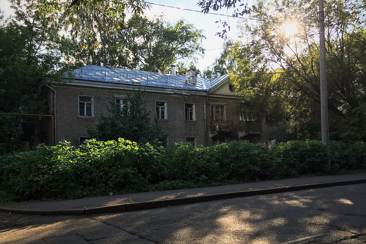 Двухэтажный кирпичный малоэтажный сталинский дом 1950 года постройки в зелёном дворе