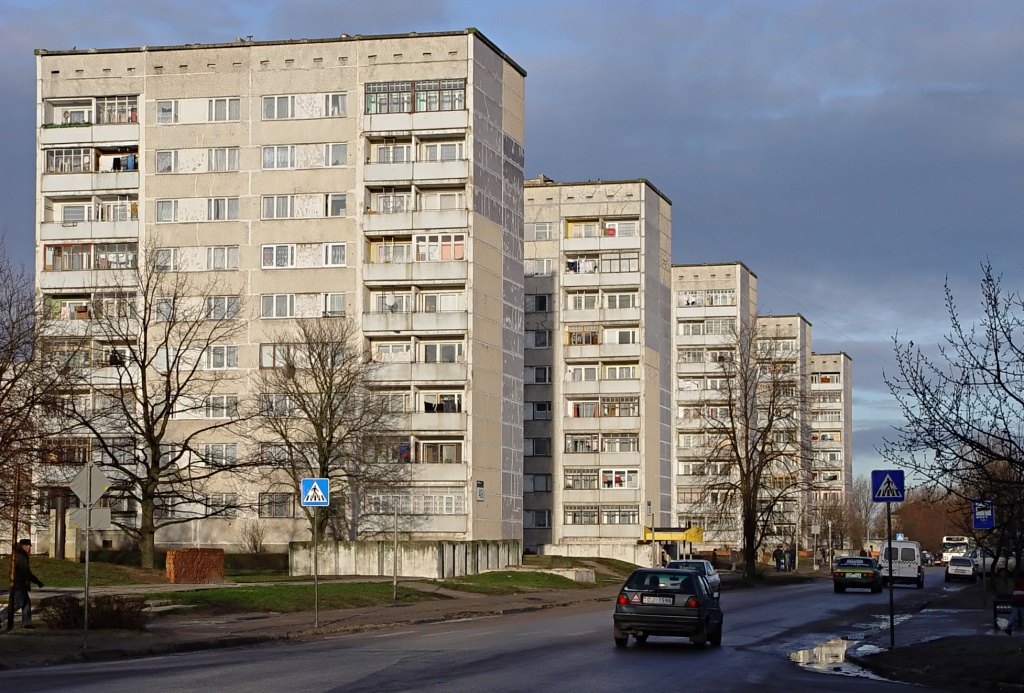 Многоэтажные панельные дома брежневской постройки вдоль городской улицы